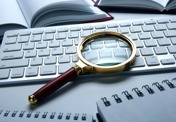 verispy review background check service magnifying glass over computer keyboard
